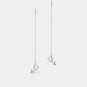 Gold earrings with chain drops on a light gray background