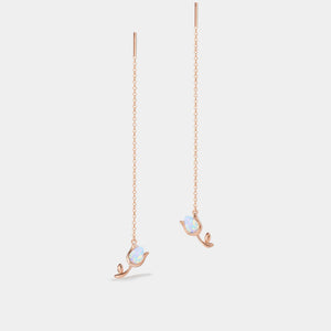 Rose gold earrings with opal stones on a light gray background