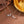 Two necklaces with leaf and pearl designs on a brown surface.