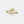 Gold ring with a pearl and leaf design on a light gray background