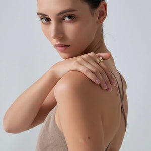 Woman wearing a beige top against a plain background