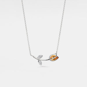 Silver necklace with leaf-shaped pendant on a white background