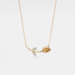 Gold necklace with leaf design on a white background