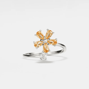 A gold-colored fidget spinner ring with a floral design and a central cubic zirconia.