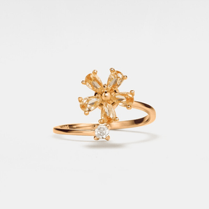 A gold-colored fidget spinner ring with a floral design and a central cubic zirconia.