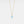 Gold necklace with a blue gemstone pendant on a light gray background