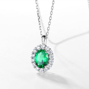 Green gemstone pendant with silver chain on a white background