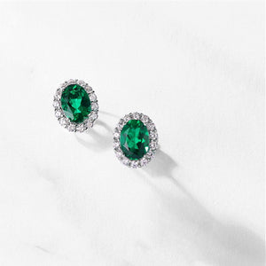 Pair of emerald green gemstone earrings on a white background