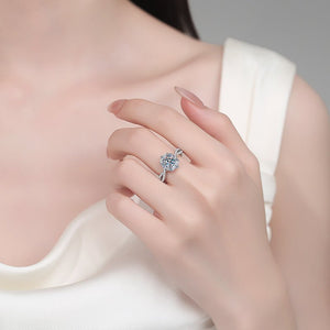 Close-up of a hand wearing a diamond ring on a neutral background