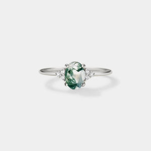 Silver ring with a green gemstone on a white background