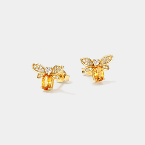 Gold bee-shaped earrings with gemstones on a white background