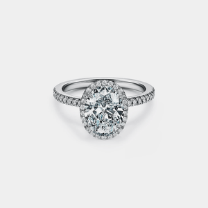 Diamond ring with a halo on a light gray background