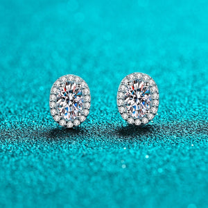 Pair of diamond earrings on a turquoise glittery background