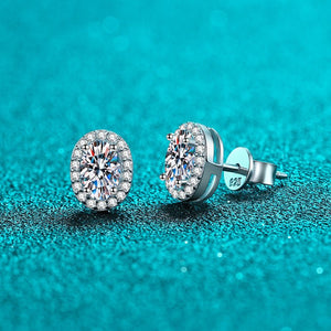 Silver stud earrings with clear gemstones on a teal glittery background