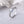 Silver ring with a central blue gemstone on a white fabric background
