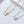 Two necklaces with opal stones on gold and silver chains against a light background