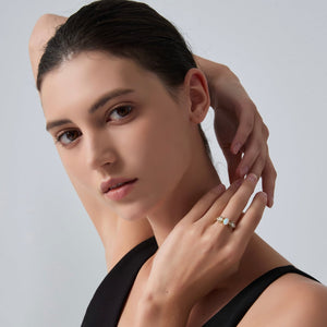 Woman wearing a ring on her finger against a plain background