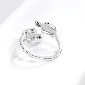 Silver turtle-shaped ring with opal stones and 'I love you forever' engraving on a white background