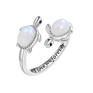 Silver turtle-shaped ring with opal stones and 'I love you forever' engraving on a white background