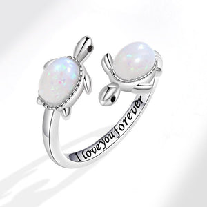Silver turtle-shaped ring with opal stones and 'I love you forever' engraving on a white background