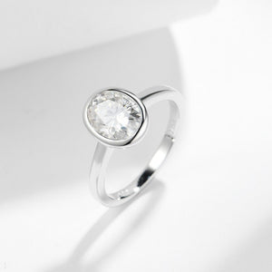 Silver ring with a clear gemstone on a light gray background