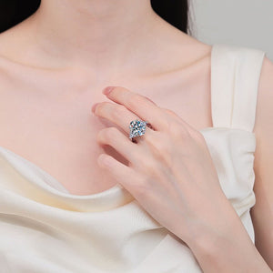 Close-up of a hand wearing a diamond ring on a white fabric background