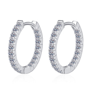 Silver hoop earrings with small stones on a white background