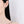 Close-up of a person wearing a silver hoop earring on a plain background