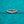 Rose gold ring with a diamond on a teal glittery background