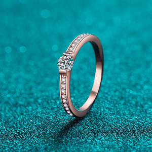 Rose gold ring with diamonds on a teal background