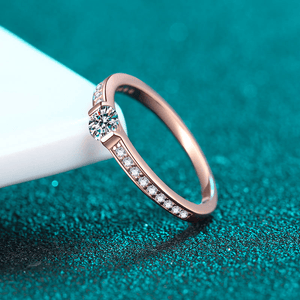 Rose gold ring with diamonds on a teal background
