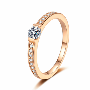 Rose gold ring with a central diamond and smaller diamonds on a white background