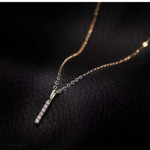 Gold necklace with a pendant on a dark textured background