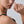 Woman wearing a gold ring on her finger against a neutral background