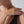 Close-up of a person's hand with a gold ring on a neutral background