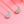 Two necklaces with teardrop-shaped pendants on a pink background