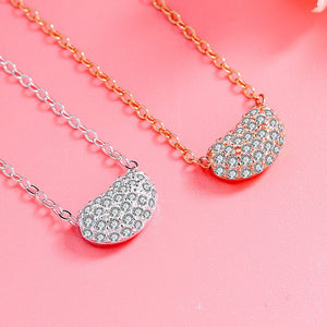 Two necklaces with teardrop-shaped pendants on a pink background