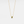 Gold necklace with a green gemstone pendant on a light gray background
