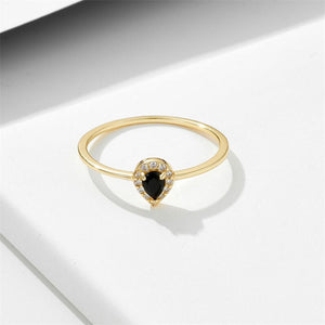 Gold ring with a black gemstone and diamonds on a white background