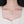 Teardrop-shaped necklace with a pendant on a person wearing a white shirt.