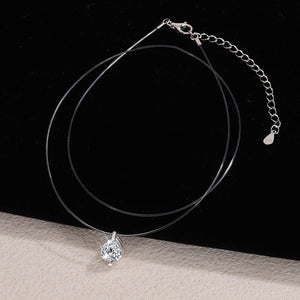 Silver necklace with a teardrop-shaped pendant on a black background