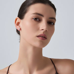 Close-up of a woman wearing a black strappy top against a light gray background