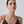 Woman wearing a black strappy top against a plain background
