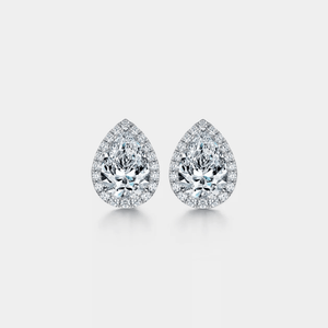 Pair of pear-shaped moissanite earrings on a light gray background