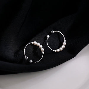 Pearl hoop earrings on a black fabric background