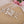 Decorative hair comb with pearls and crystals on a textured surface with flowers in the background