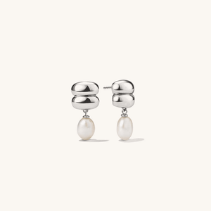 Silver earrings with pearl drops on a white background