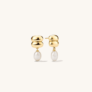 Gold earrings with pearl drops on a white background
