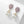 Pair of earrings with purple gemstones and pearl-like elements on a light background