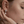 Close-up of a person wearing a pearl earring with a blurred background